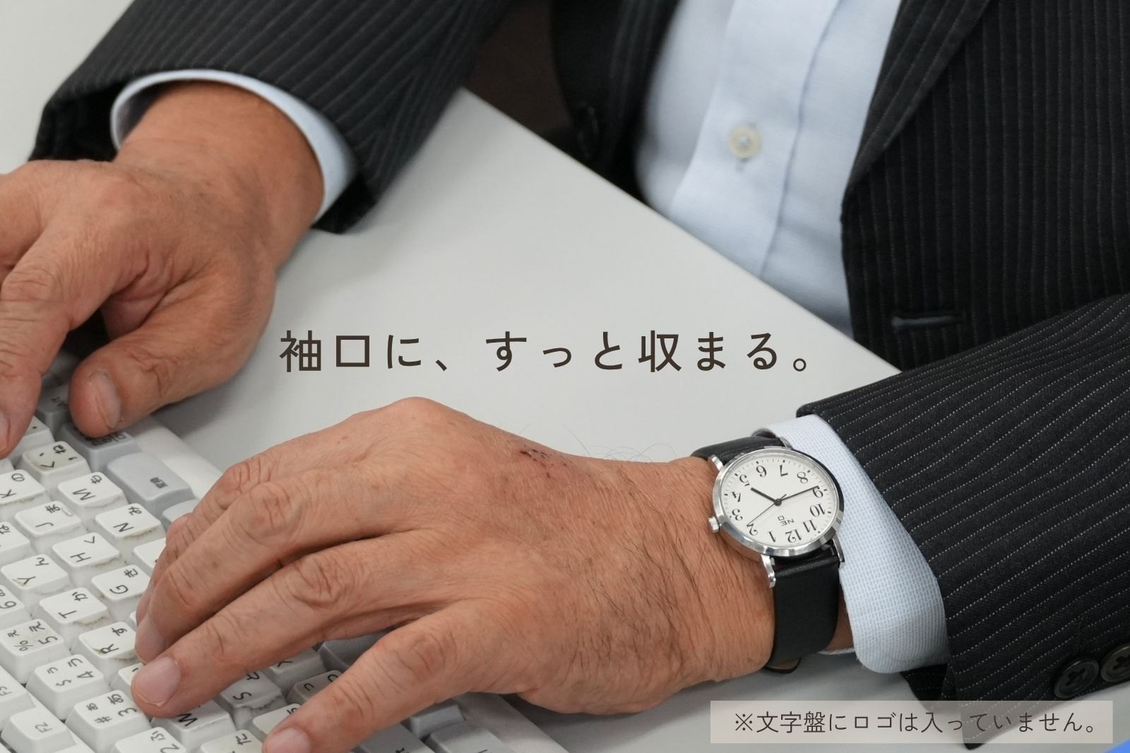 スーツの袖元に N watch を合わせた様子